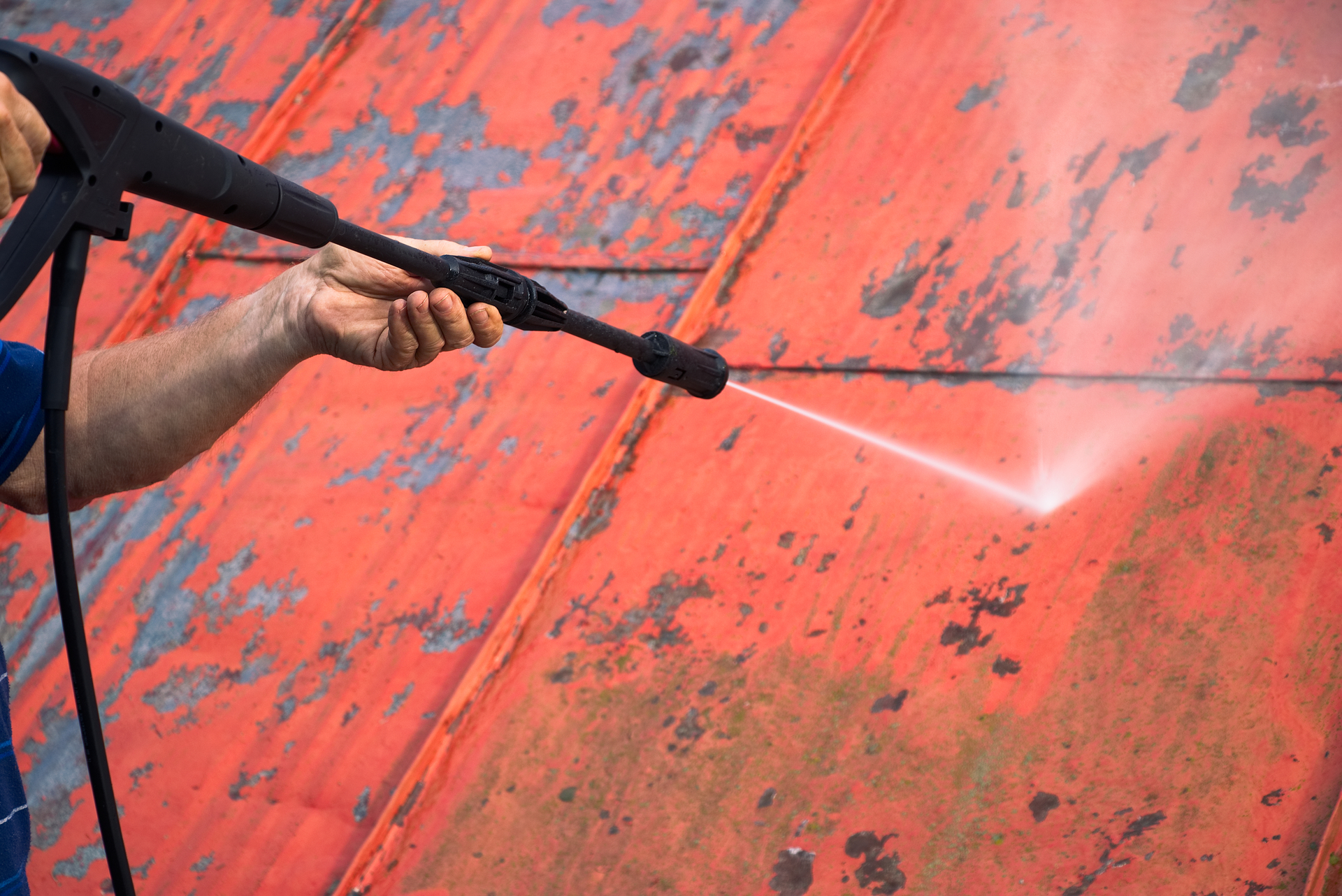 worker-power-washing-rusted-surface